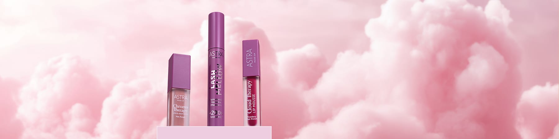 Cosmetici Astra con mascara e rossetti della linea Cloud Fairy su sfondo nuvoloso rosa