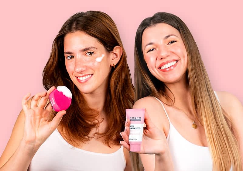Donne con prodotti per la cura della pelle firmati FOREO su sfondo rosa