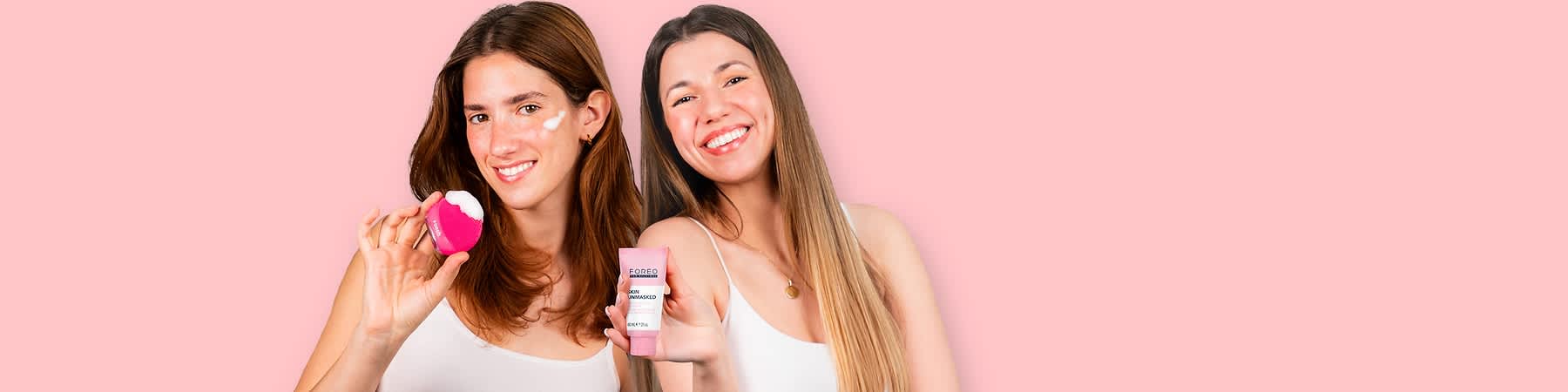 Donne con prodotti per la cura della pelle firmati FOREO su sfondo rosa