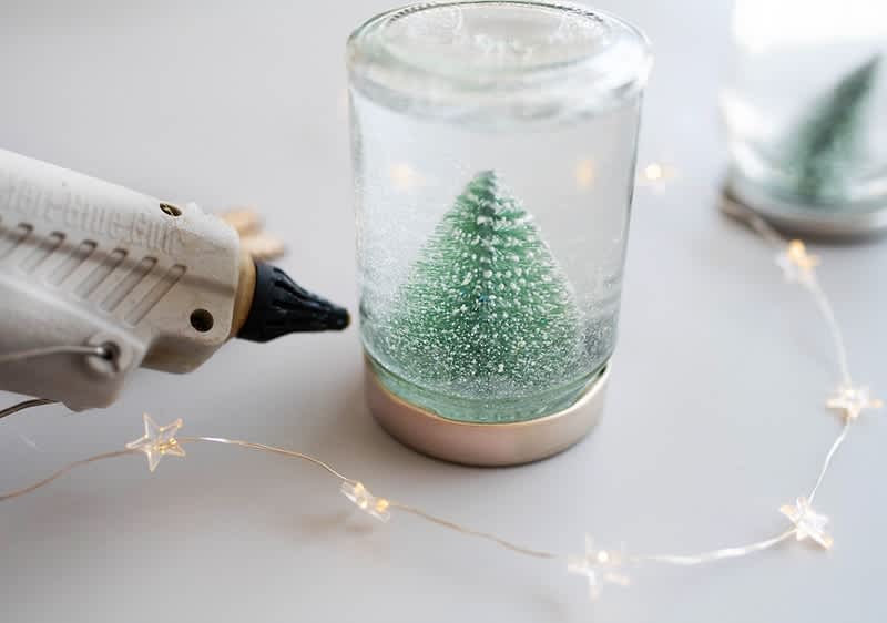 Decorazione natalizia con albero in barattolo e luci e pistola a caldo