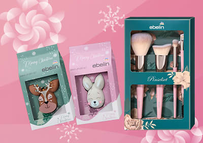 Set regalo a marchio ebelin su sfondo rosa con fiocchi di neve bianchi