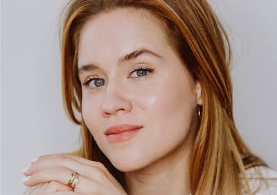 Primo piano di ragazza bionda con make-up da giorno su sfondo neutro