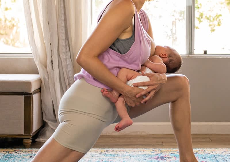 Madre fa esercizi mentre tiene in braccio il suo bambino