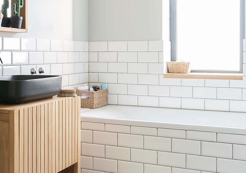 Bagno moderno con piastrelle bianche e vasca