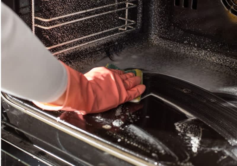 Una forno viene pulito con la spugna.