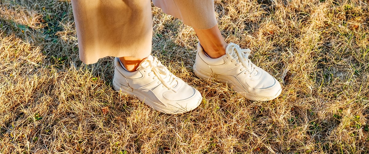 Scarpe bianche su erba secca