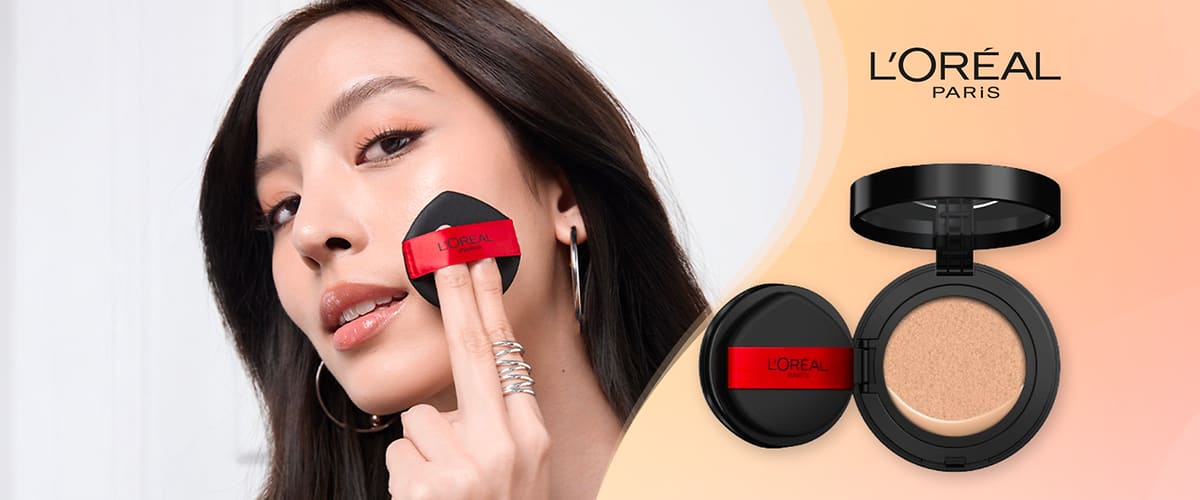 Sulla sinistra modella applica L'Oréal Paris Cushion Foundation, sulla destra immagine del prodotto con logo L'Oréal Paris su sfondo rosa sfumato.