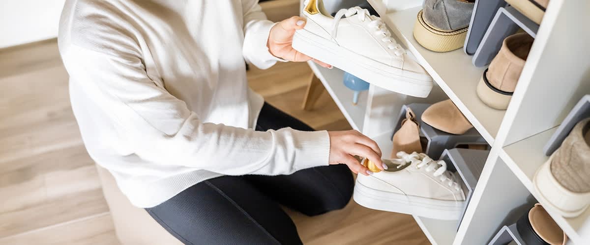 Delle scarpe vengono sistemate su una scarpiera.