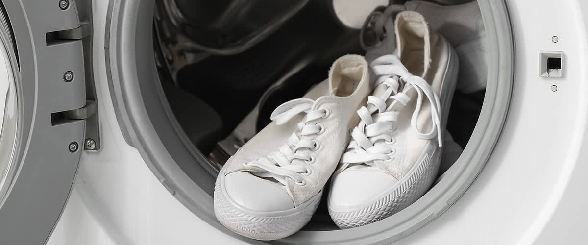 Scarpe bianche con lacci nel cestello della lavatrice