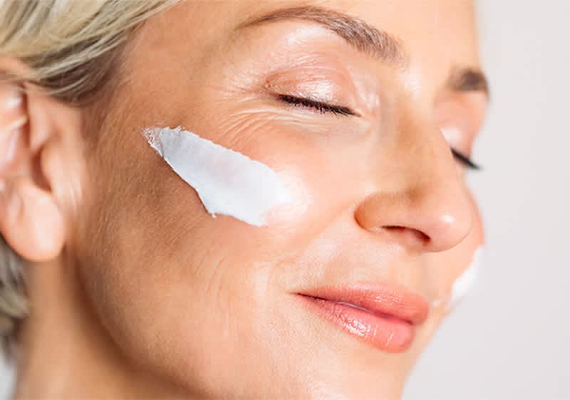 Donna con crema per la couperose sul viso.