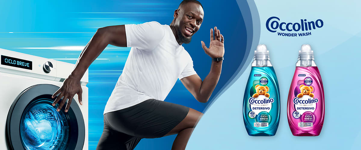Coccolino Wonder Wash bottiglie rosa e azzurra e uomo che corre su sfondo azzurro.