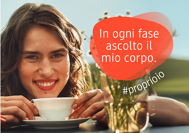 Donna che tiene in mano una tazza. Accanto il testo "In ogni fase ascolto il mio corpo"