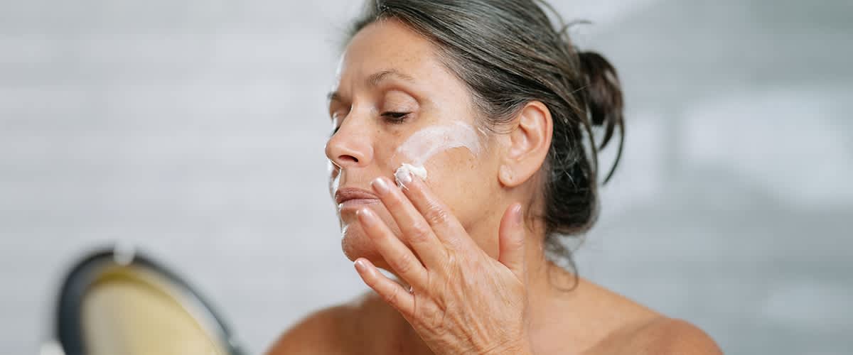 Donna applica crema al PDRN.