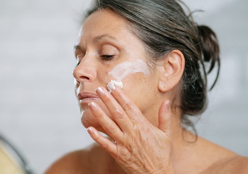 Donna applica crema con PDRN.