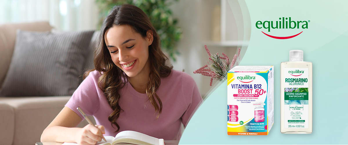 Donna che scrive con due prodotti Equilibra integratori vitamina B12 e shampoo al rosmarino