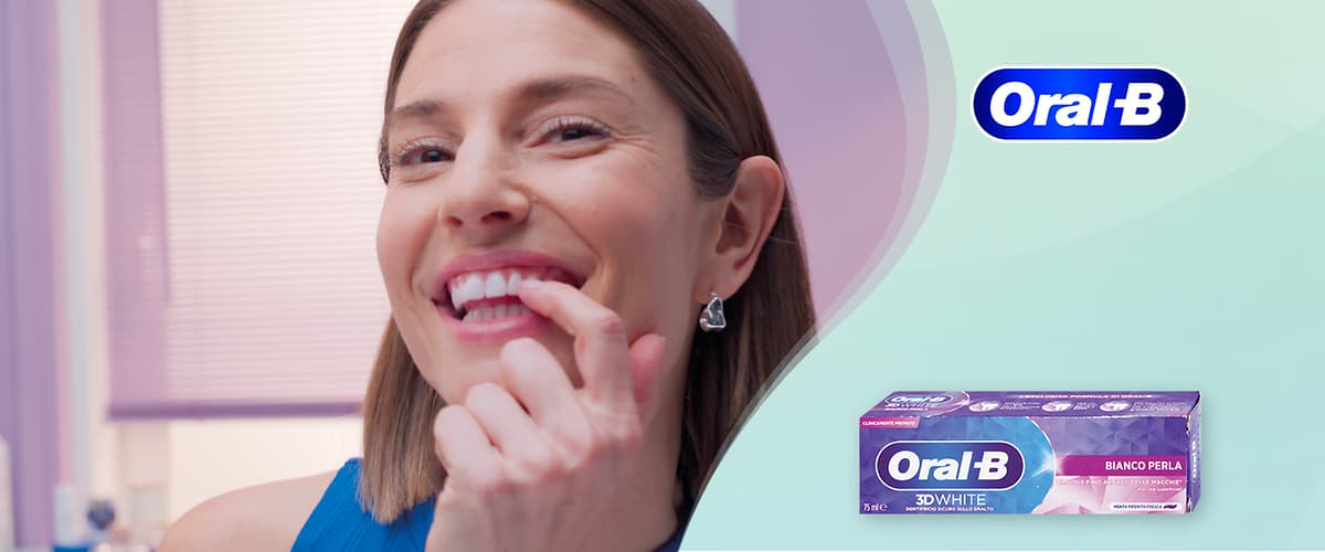 Donna sorridente che mostra i denti e confezione di dentifrico Oral-B