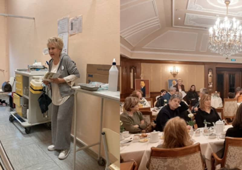 Sala elegante con lampadario a gocce e pareti decorate, tavoli apparecchiati coperti da tovaglie bianche e molte persone sedute che partecipano a una riunione o evento conviviale, a sinistra una donna in piedi vicino a un carrello con materiali