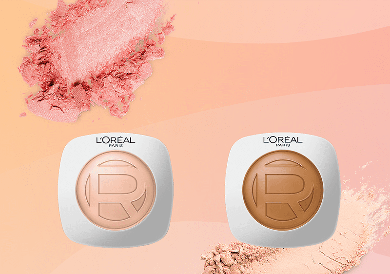 Due fondotinta L'Oréal Paris in astucci bianchi arrotondati, a sinistra tonalità chiara beige con grande R stampata al centro, a destra tonalità scura bronzo con R centrale, sfondo sfumato pesca con ombretti polverosi rosa e beige