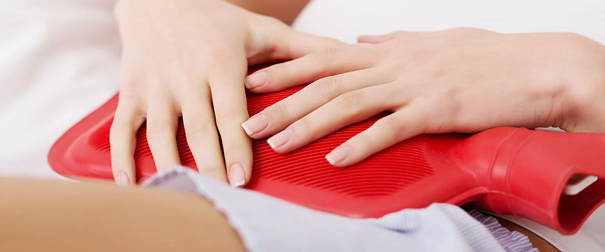 Kobieta z termoforem na brzuchu