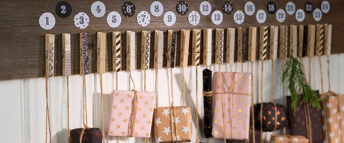 Adventskalender mit verzierten Holzklammern