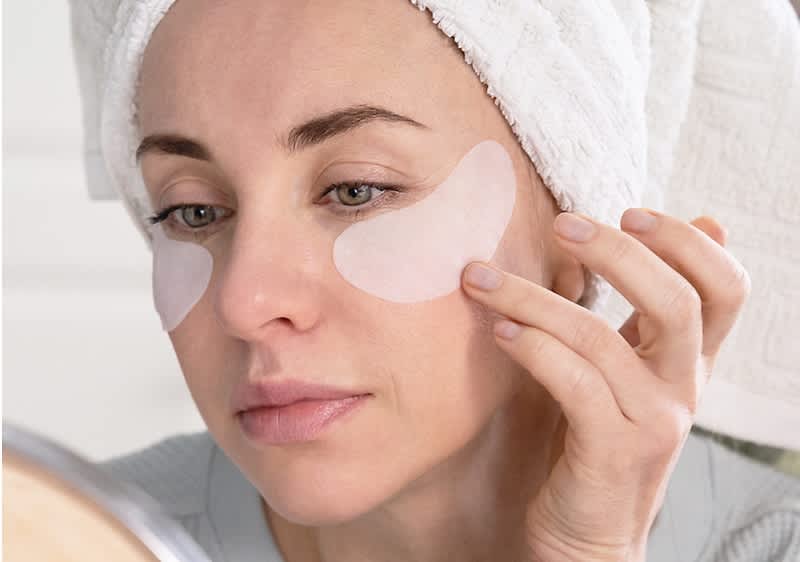 Kobieta pielęgnująca skórę pod oczami za pomocą plasterków