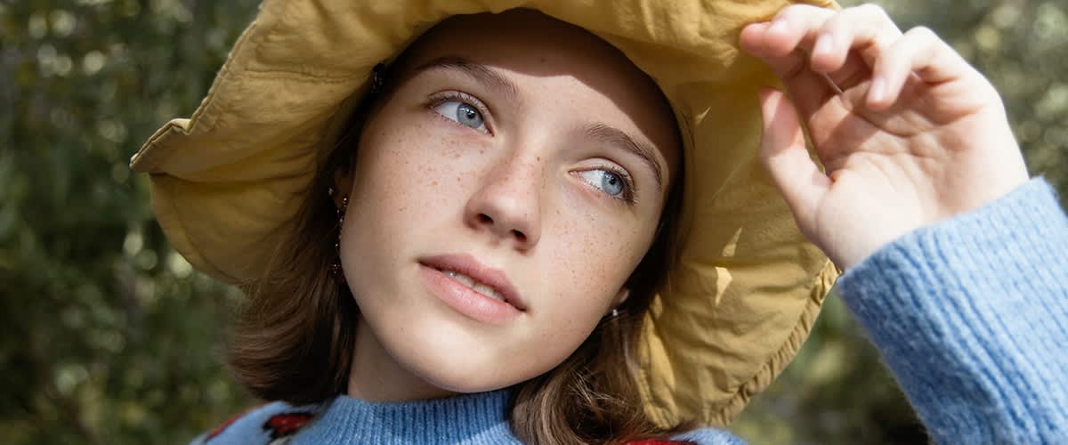 Junge Frau blickt in die Sonne