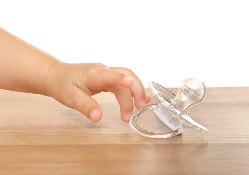 Baby greift nach einem Schnuller