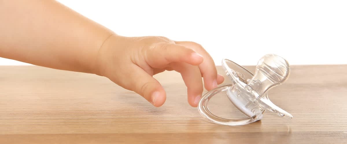 Baby greift nach einem Schnuller