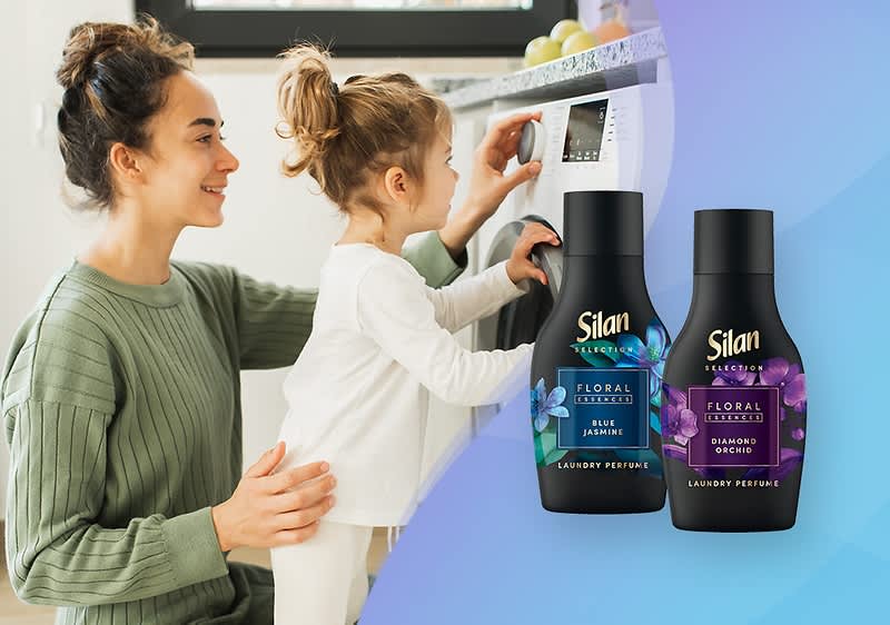 Dwa czarne opakowania kosmetyków marki Silan Blue Jasmine oraz Diamond Orchid , jedno z niebieską etykietą, drugie z fioletową, na jasnym tle z falistym wzorem.