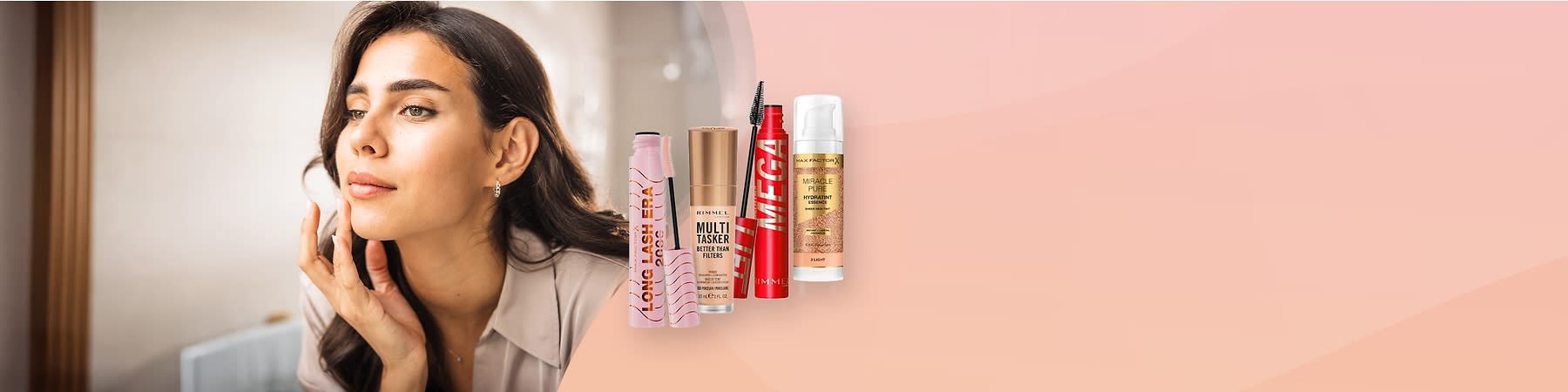 Kobieta z długimi ciemnymi włosami przed lustrem, obok produkty do makijażu marek Rimmel London i Max Factor.