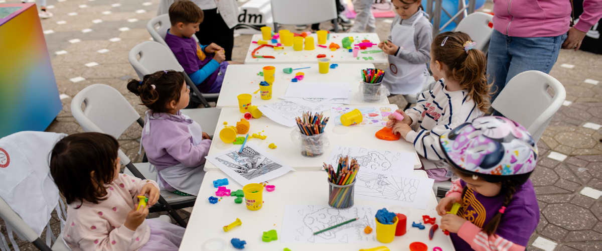 Copii la masă de activități cu plastilină și creioane colorate