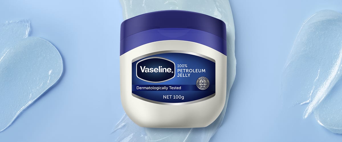 Recipient de Vaseline pe fundal albastru deschis cu gel transparent