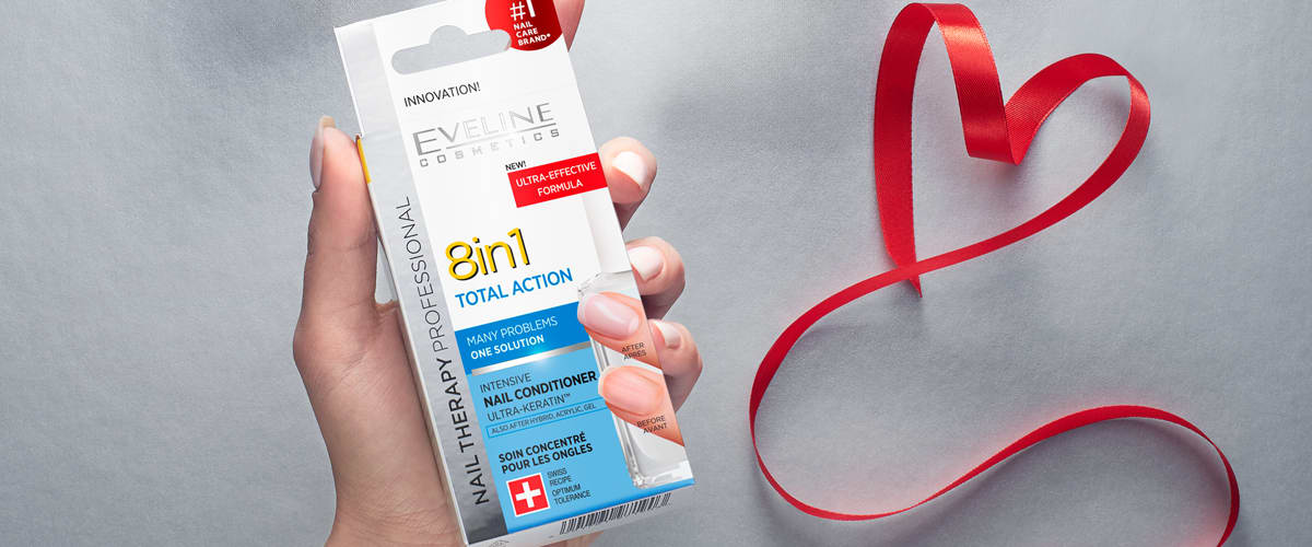 Mână ținând un produs Eveline Cosmetics 8in1 lângă o panglică roșie