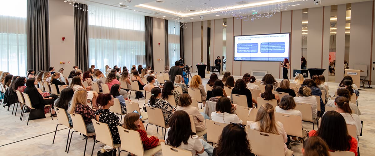 Participanți la o conferință într-o sală modernă