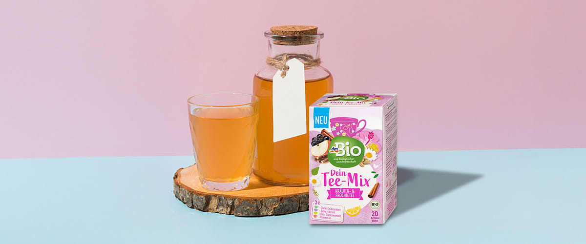 Ceai bio cu fructe de pădure și scorțișoară lângă sticlă și pahar pe suport de lemn