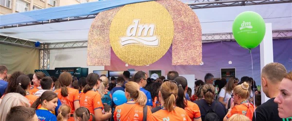 Cuvânt cheie principal: maraton Imagine: Participanți la maraton adunați sub un banner DM