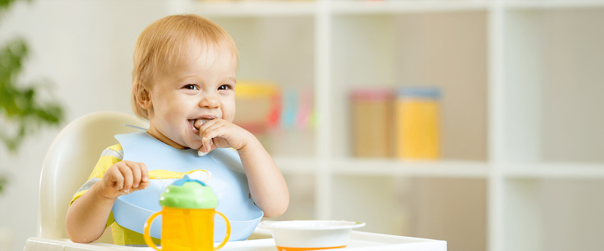 Cuvântul cheie principal: bebeluș Bebeluș mâncând cu linguriță și bavețică la masă