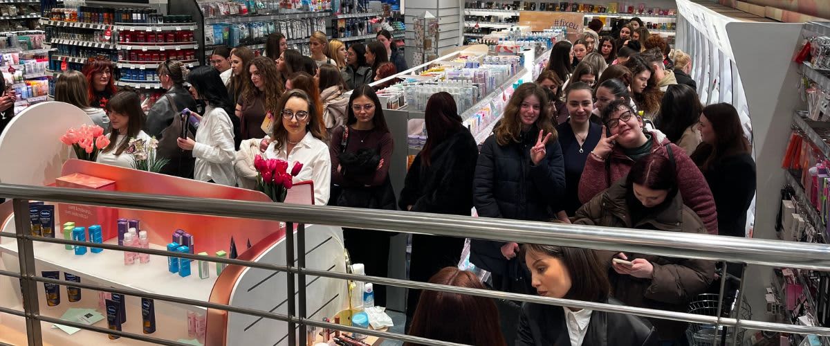 Oameni stând la coadă aglomerată într-un magazin de cosmetice