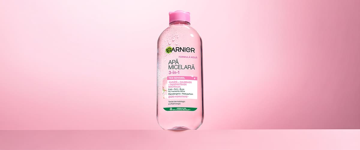 Apă micelară Garnier 3 în 1 pe fundal roz cu sticlă transparentă și capac roz