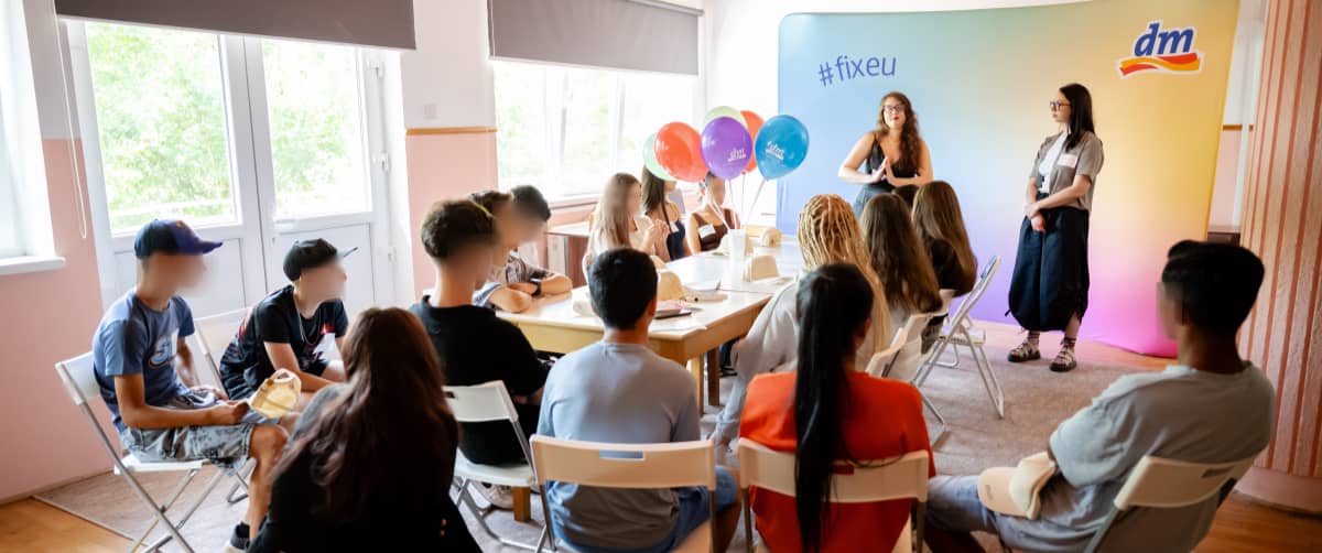 Atelier pentru adolescenți cu grup într-o sală iar două prezentatoare în față