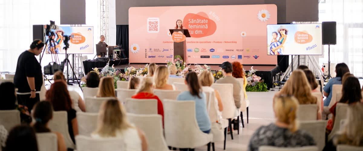 Sănătate feminină conferință cu vorbitor pe scenă și audiență în sală
