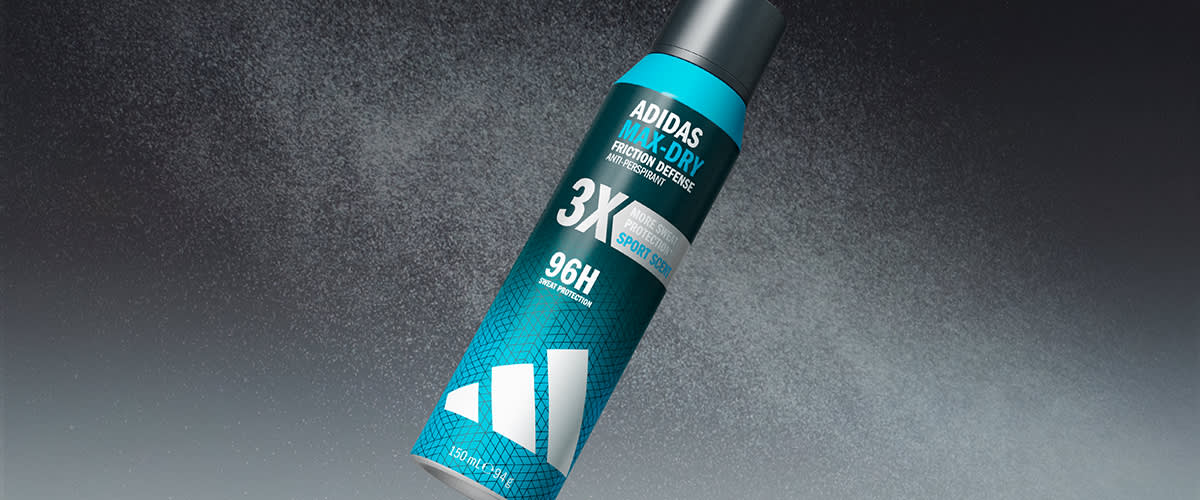 Un aerosol albastru-verde de deodorant Adidas 3K MAX DRY cu inscripțiile „3X”, „96H” și sigla Adidas, design geometric alb pe fundal gri pulverulent