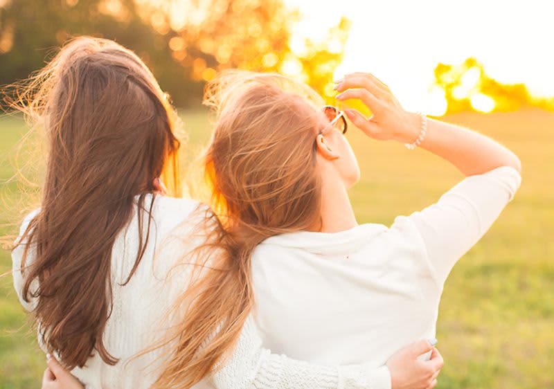 Două femei pe o pajiște.