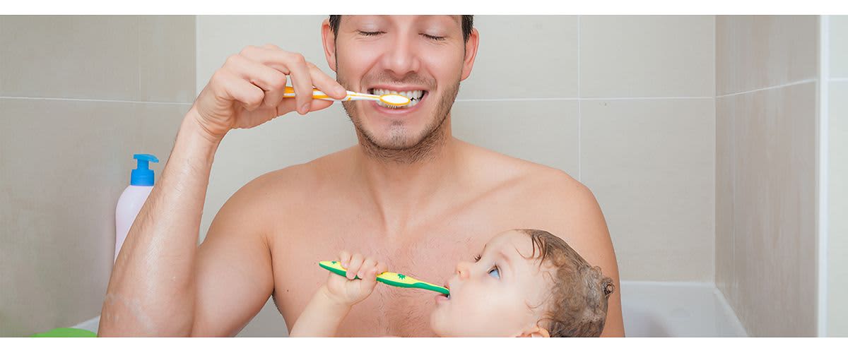 Tata și copilul periindu-se pe dinți