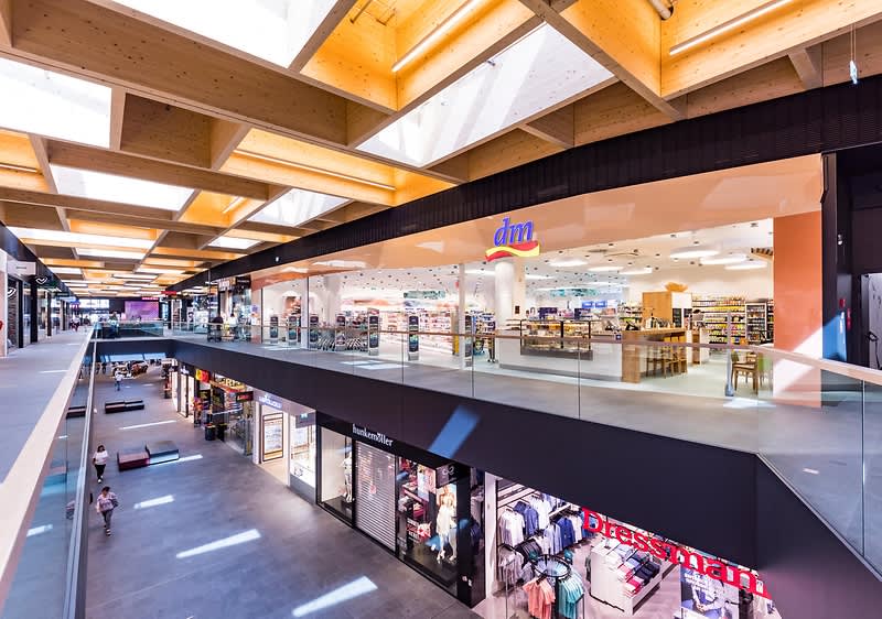Interiorul unui centru comercial modern cu magazine și lumină naturală