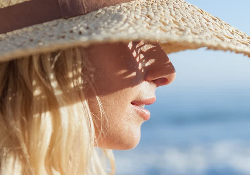 Frau mit Sonnenhut und blonden Haaren