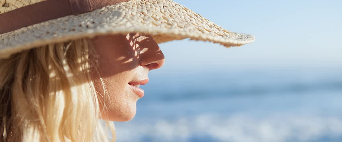 Frau mit Sonnenhut und blonden Haaren