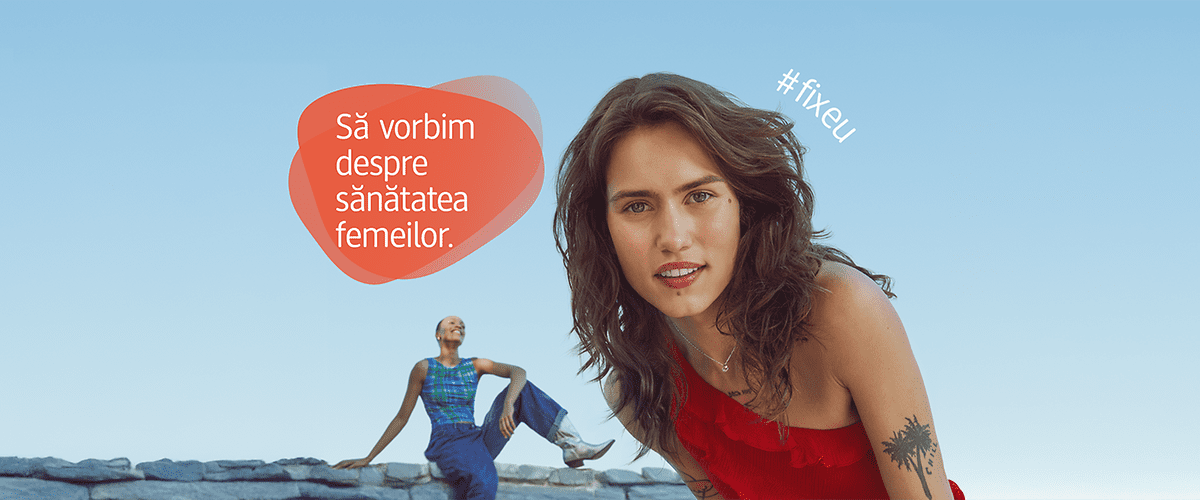 Femeie în rochie roșie și femeie în salopetă albastră pe fundal albastru