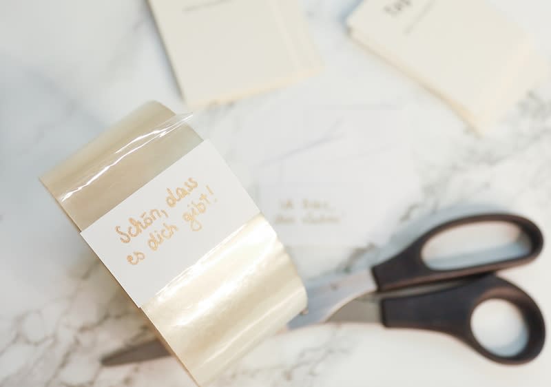 Kompliment auf Zettel, Klebeband und Schere