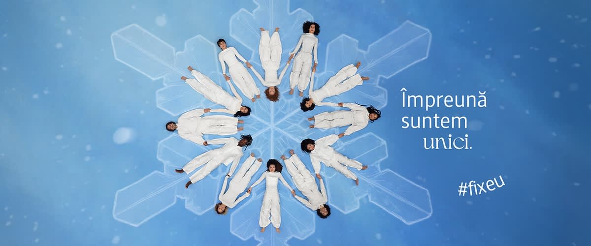 Oameni în alb formând un fulg de zăpadă pe fundal albastru cu text Împreună suntem unici